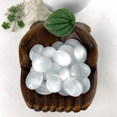 selenite palm stones with decorations in the background