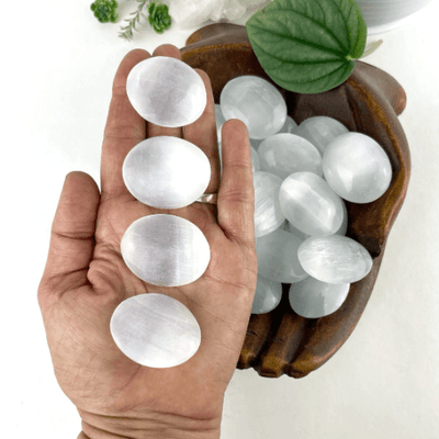 selenite palm stones with decorations in the background