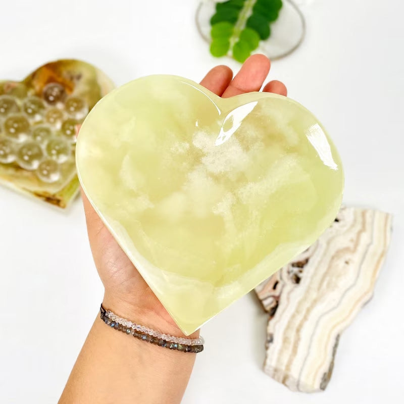 Green Mexican Onyx Heart Bowl in a hand for size reference
