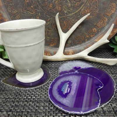 Set of 4 purple agate slice coasters with a silver electroplated edge used as a coaster