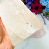 Close up view of Crystal Quartz Semi Polished Tower Point on hand for reference.