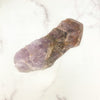 Seven Mineral Semi Polished Crystal Stone on marble background for reference.