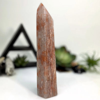 hematite point with decorations in the background