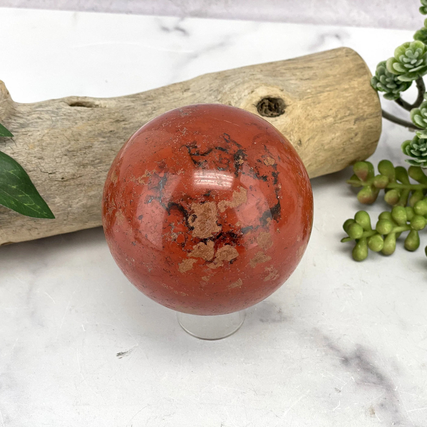 red jasper sphere with decorations in the background