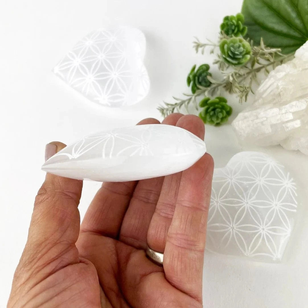 Selenite Crystal Stone Heart - Engraved with Flower of Life Pattern from a side view showing thickness
