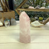 Rose Quartz Polished Point Tower Cut Base on wood surface for reference.