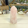 Rose Quartz Polished Point Tower Cut Base on wood surface for reference.