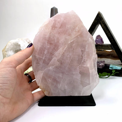 rose quartz on metal stand with decorations in the background