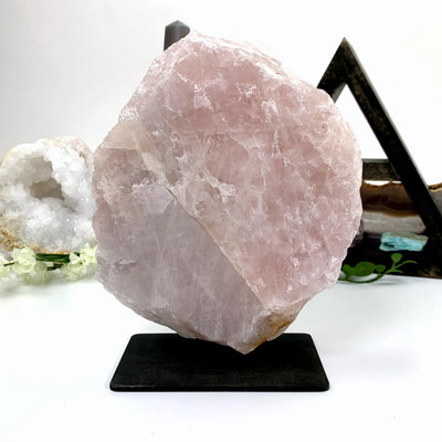 rose quartz on metal stand with decorations in the background