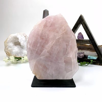 rose quartz on metal stand with decorations in the background