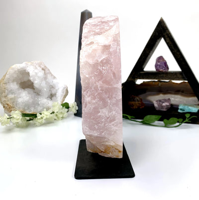 rose quartz on metal stand with decorations in the background