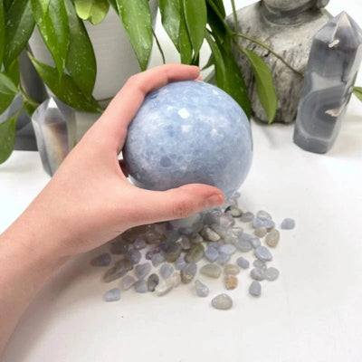 Blue Calcite Polished Sphere with a hand for size reference