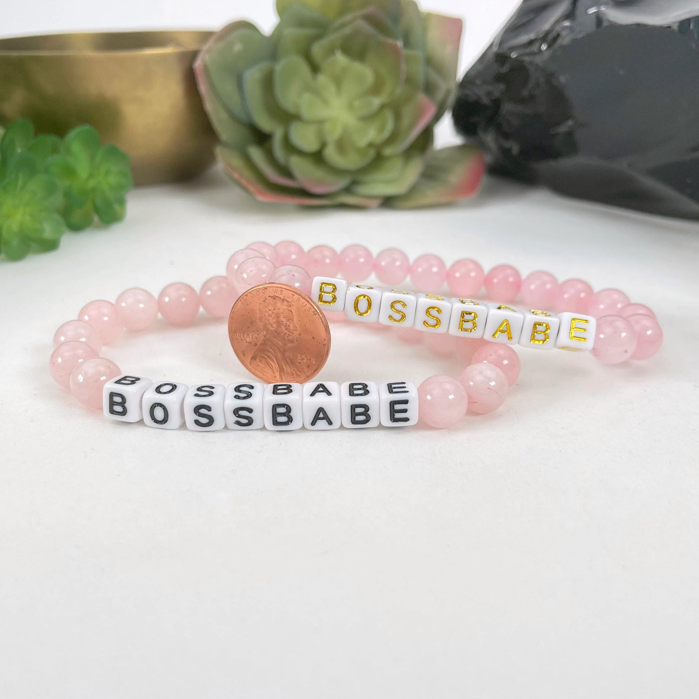 close up of rose quartz bracelet next to a coin for size reference