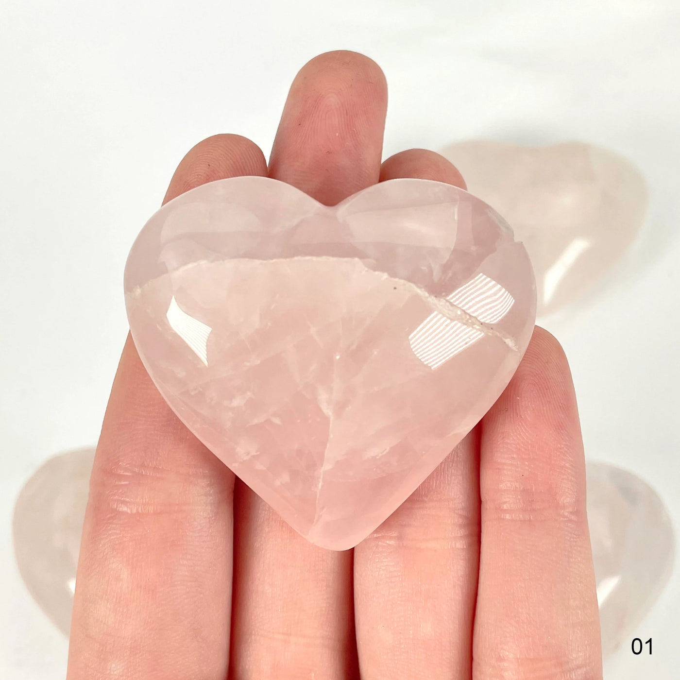 rose quartz heart with decorations in the background