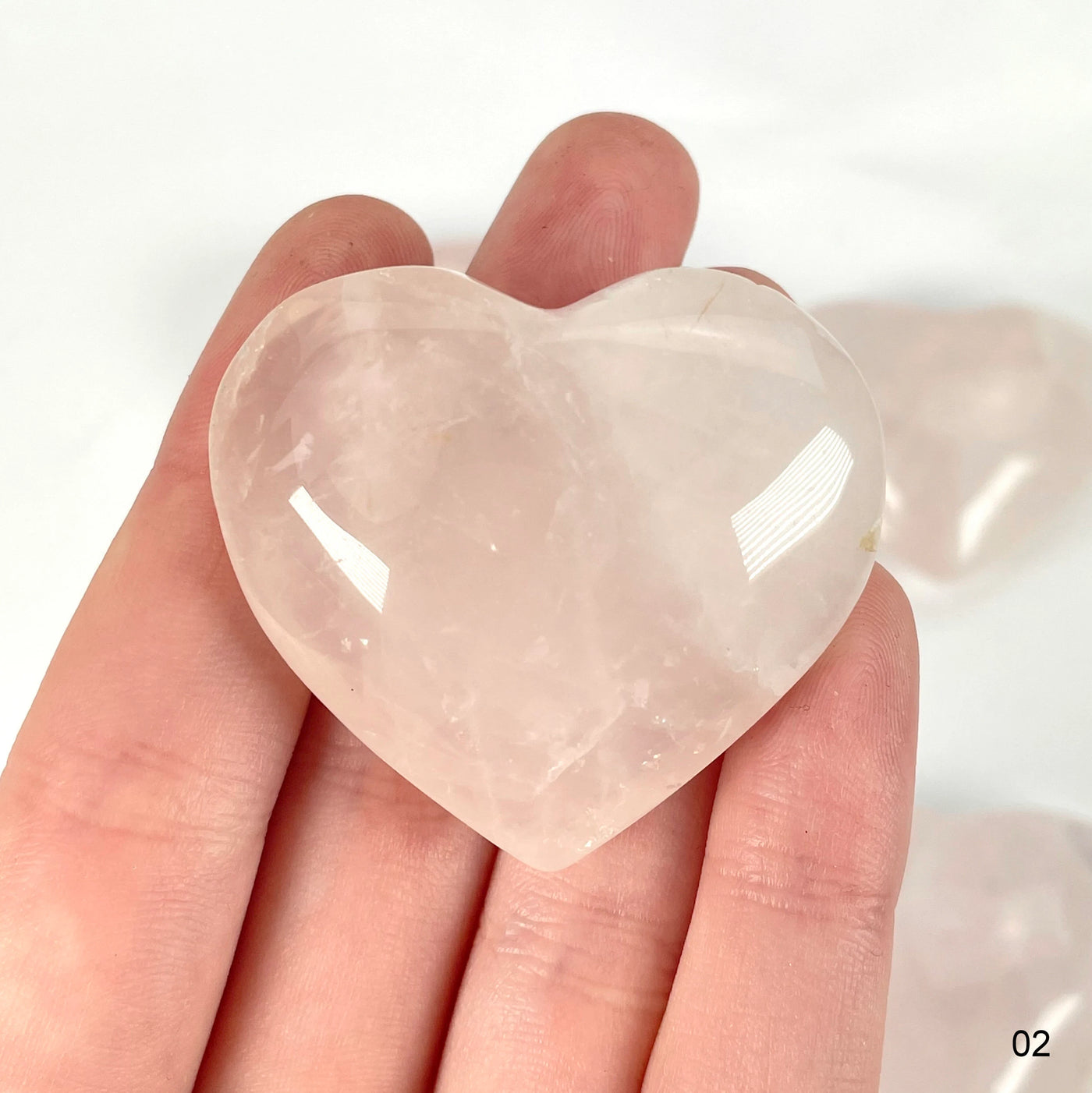 rose quartz heart with decorations in the background