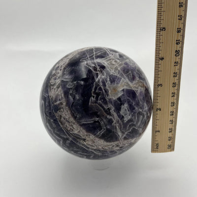 Chevron Amethyst Crystal Ball Sphere next to a ruler for sizing