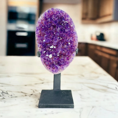 amethyst on stand with decorations in the background