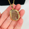 Smokey Quartz Semi Polished Gold Electroplated Pendant on hand for size reference.