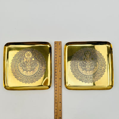 brass trays next to a ruler for size reference 