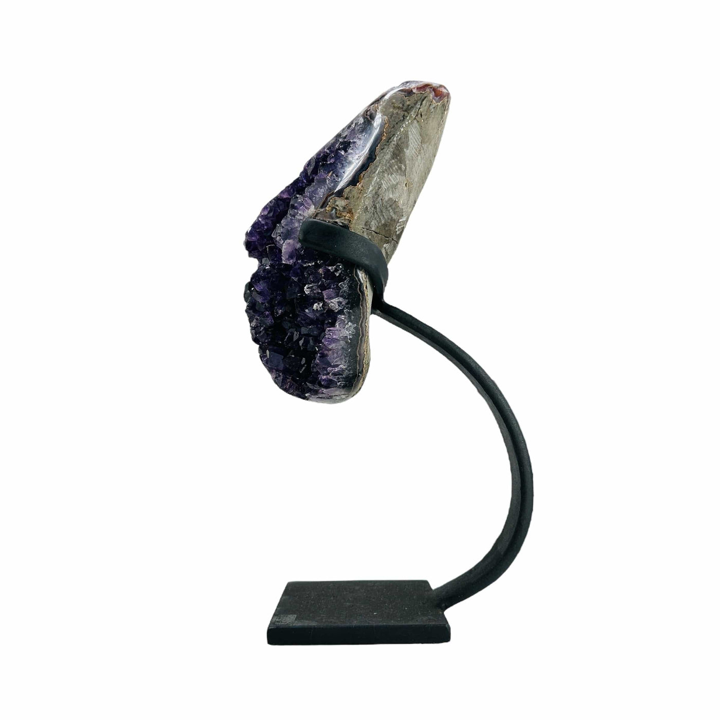 side view of semi polished geode on stand on white background