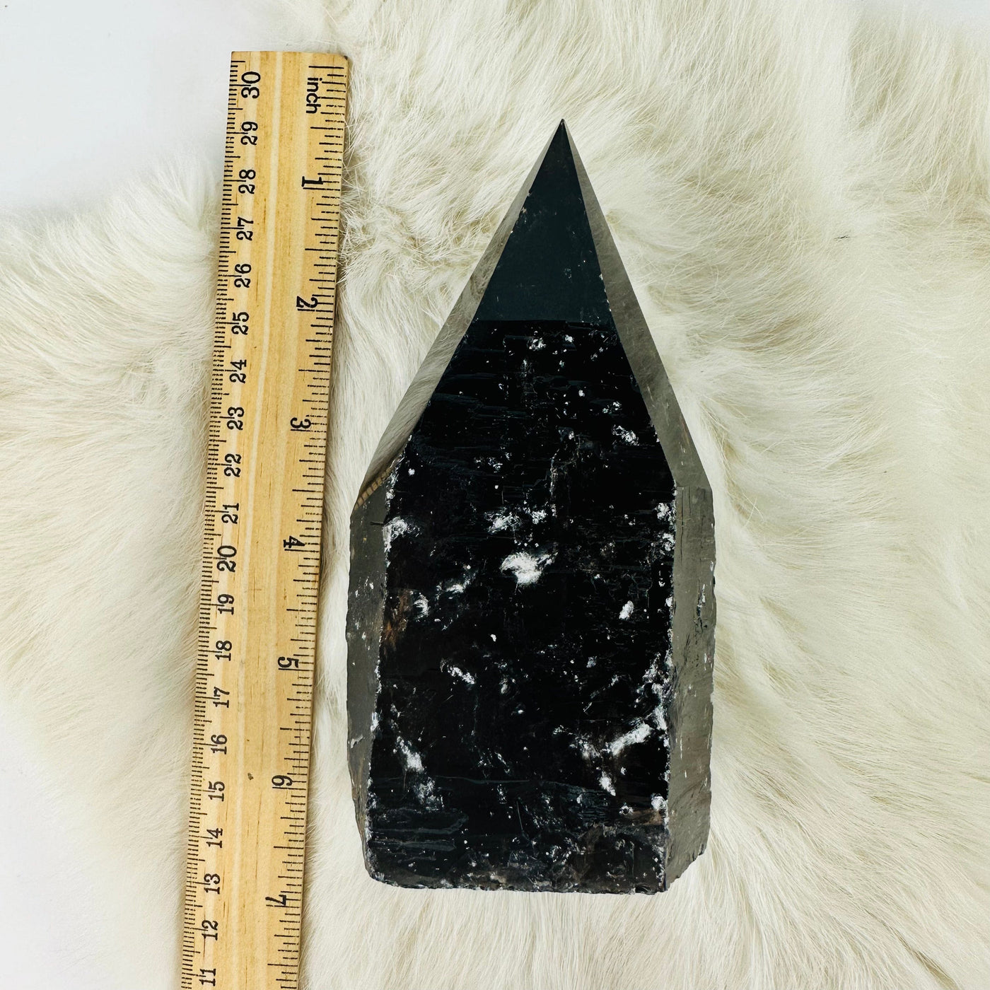 smokey quartz semi polished point next to a ruler for size reference