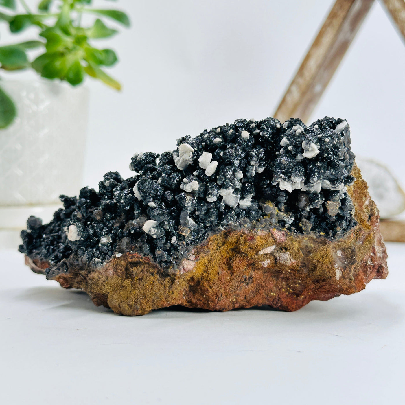 backside of goethite calcite cluster with decorations in the background