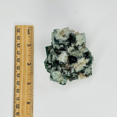 milky way fluorite next to a ruler for size reference