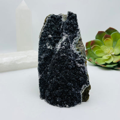 black druzy amethyst cut base with decorations in the background