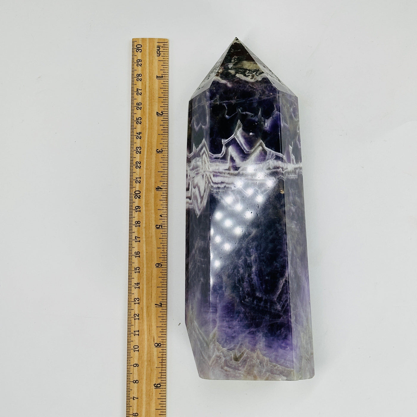 chevron amethyst polished tower next to a ruler for size reference