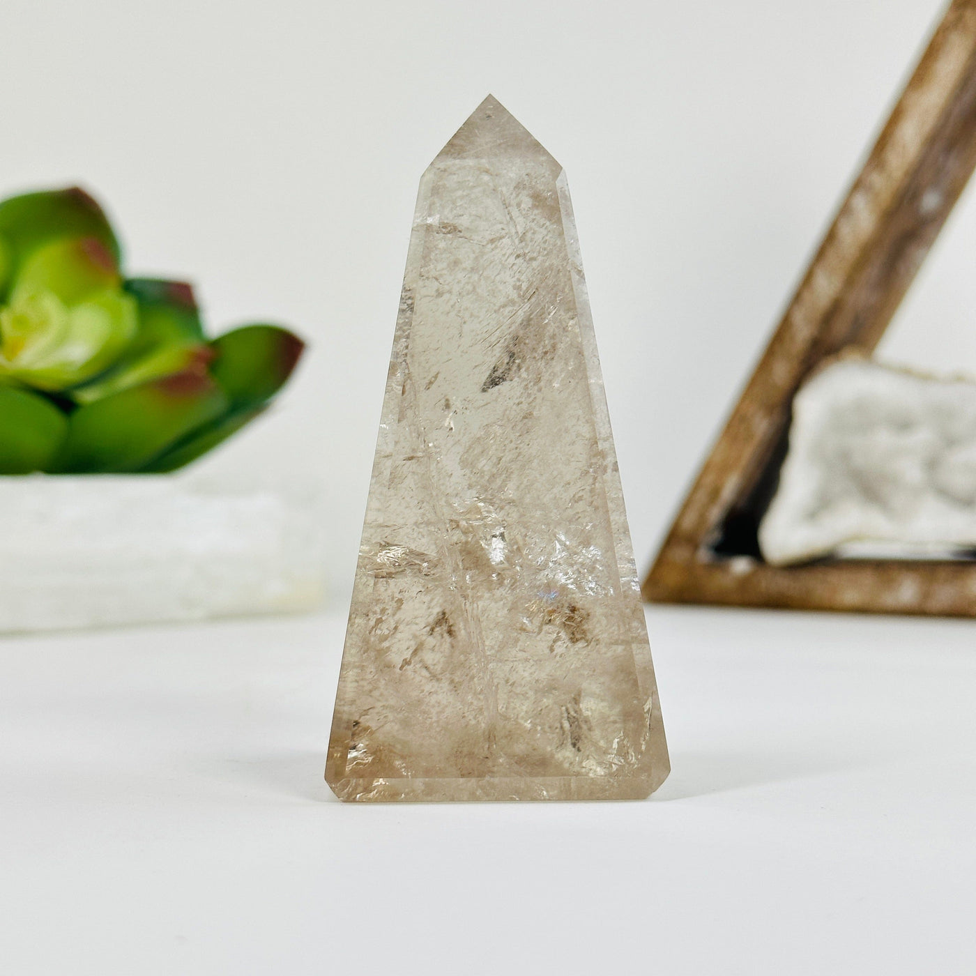 Smokey Quartz obelisk with decorations in the background