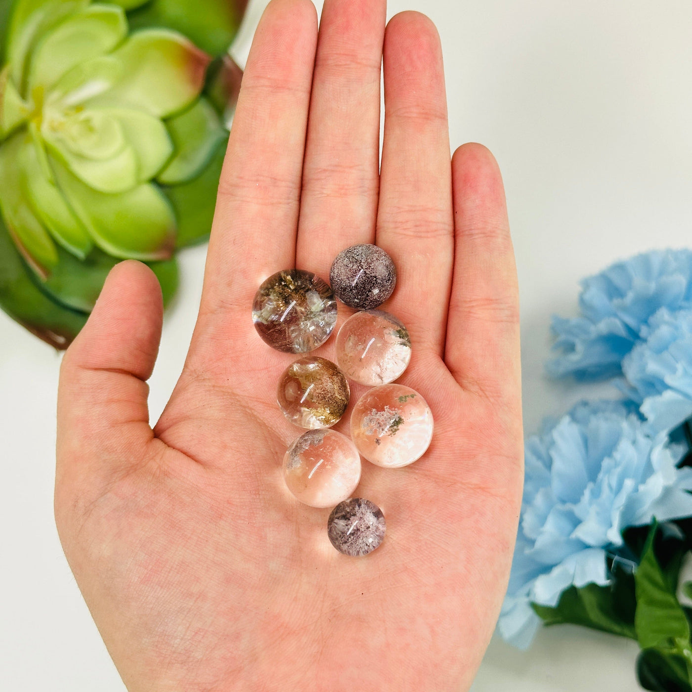 hand holding up lodalite spheres with decorations in the background