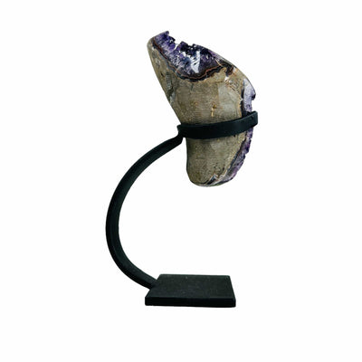 side view of semi polished geode on stand on white background