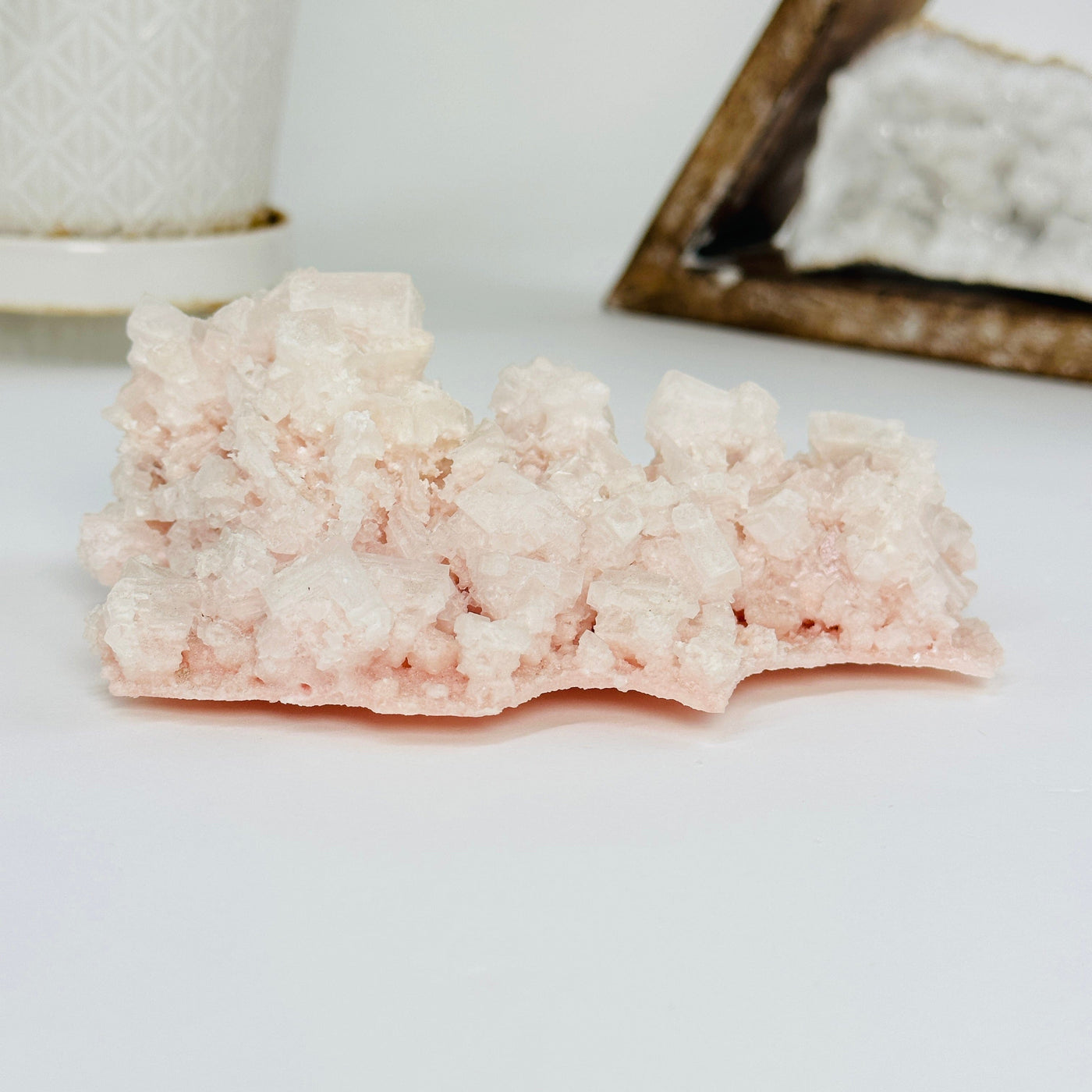 pink halite cluster with decorations in the background