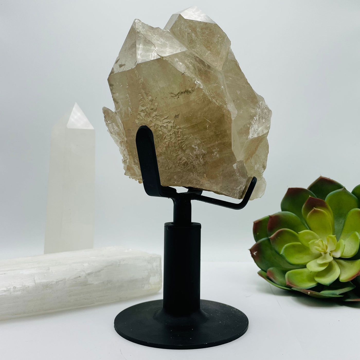 Rutilated Crystal Quartz Cluster on Metal Stand with decorations in the background