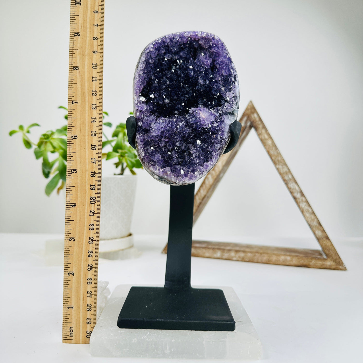 amethyst on metal stand next to a ruler for size reference