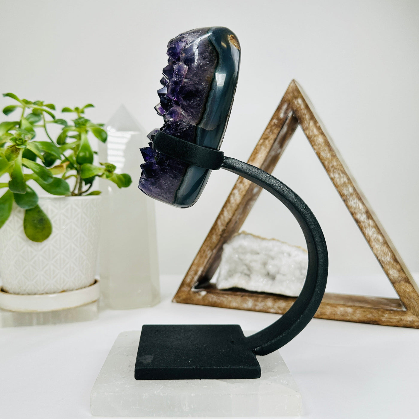 polished amethyst on stand with decorations in the background