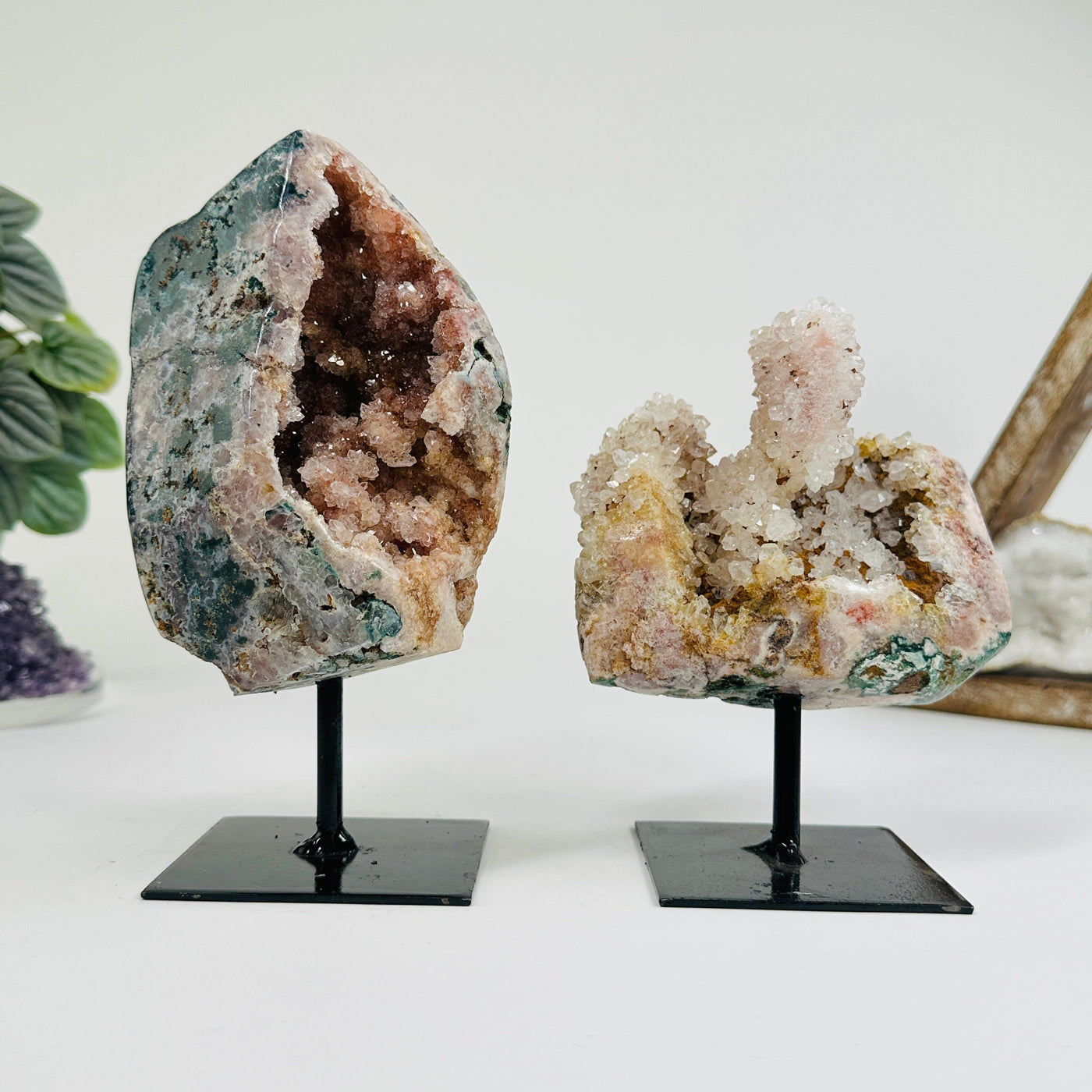 2 Pink amethyst on metal stands with decorations in the background