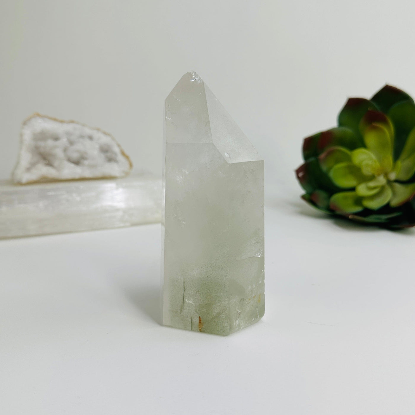 side view of Crystal quartz polished point with decorations in the background