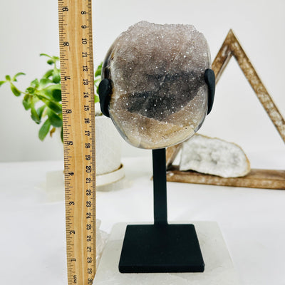 amethyst on metal stand next to a ruler for size reference