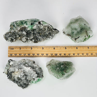 4 fluorite with pyrite and crystal quartz growth next to a ruler for size reference