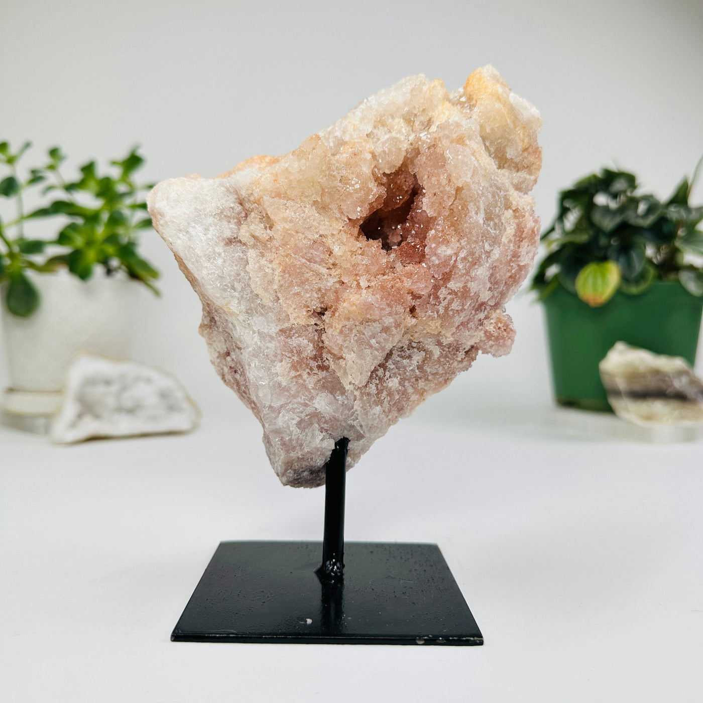 Pink amethyst on metal stand with decorations in the background