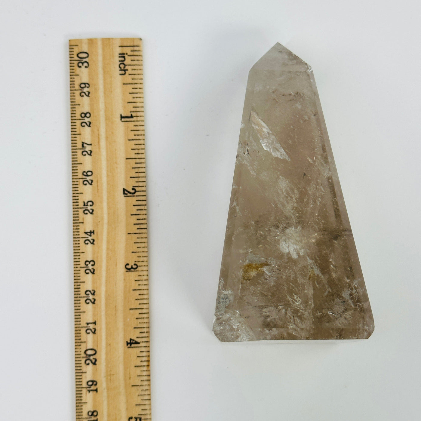 smokey quartz obelisk next to a ruler for size reference