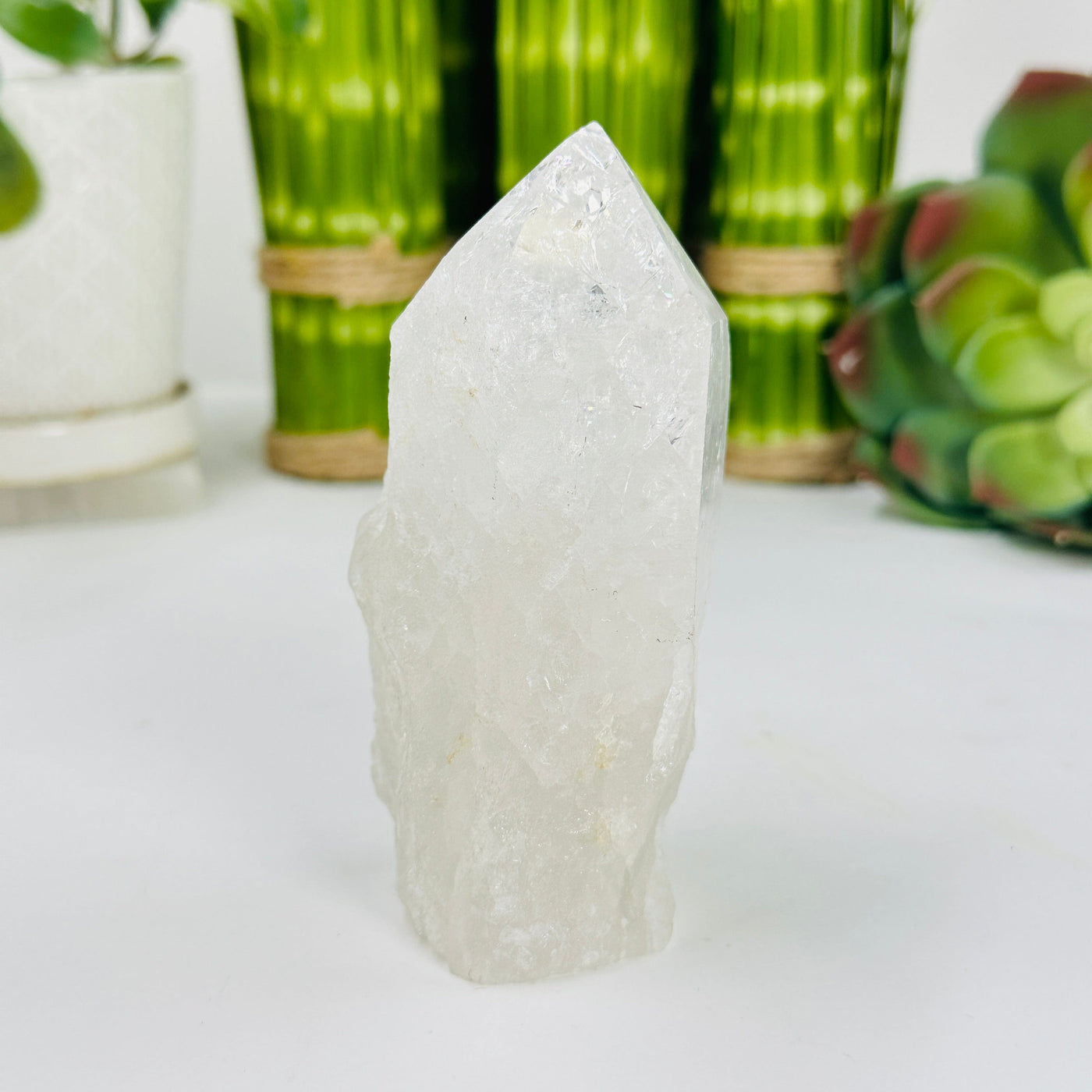 crackle quartz semi polished point with decorations in the background