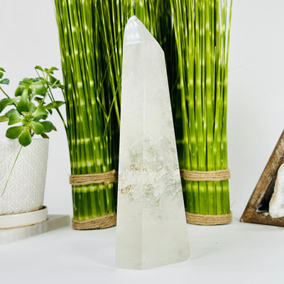 Crystal Quartz Polished Tower with decorations in the background