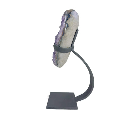 side view of amethyst on stand on white background