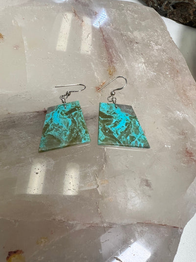 pair of turquoise earrings on crystal background