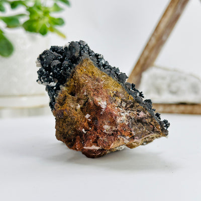 side view of goethite calcite cluster with decorations in the background