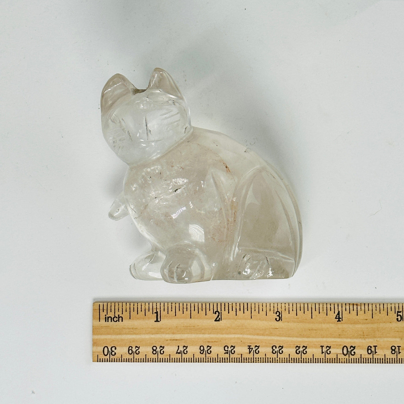 crystal quartz cat statue next to a ruler for size reference
