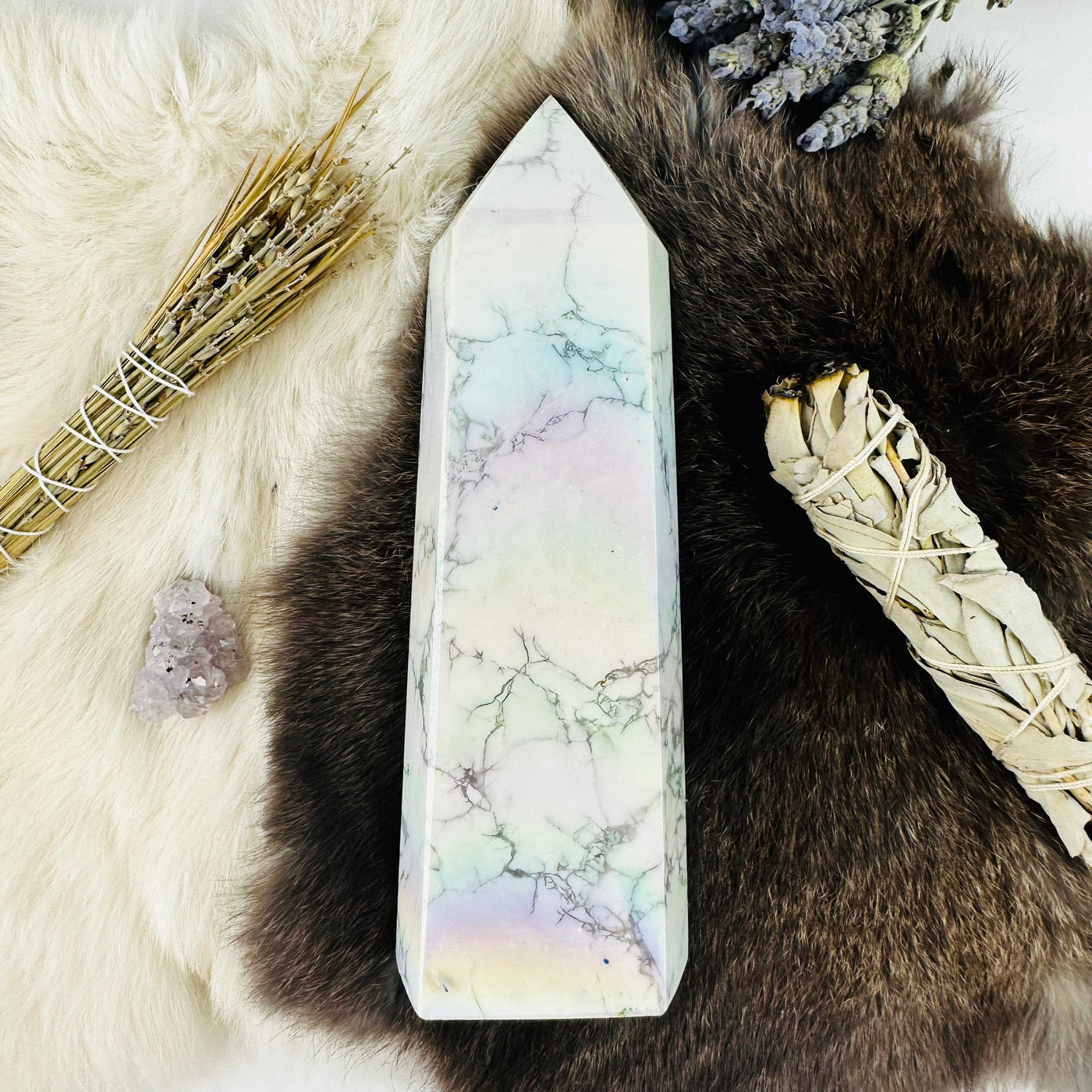 top view of White howlite aura tower on fur background with decorations