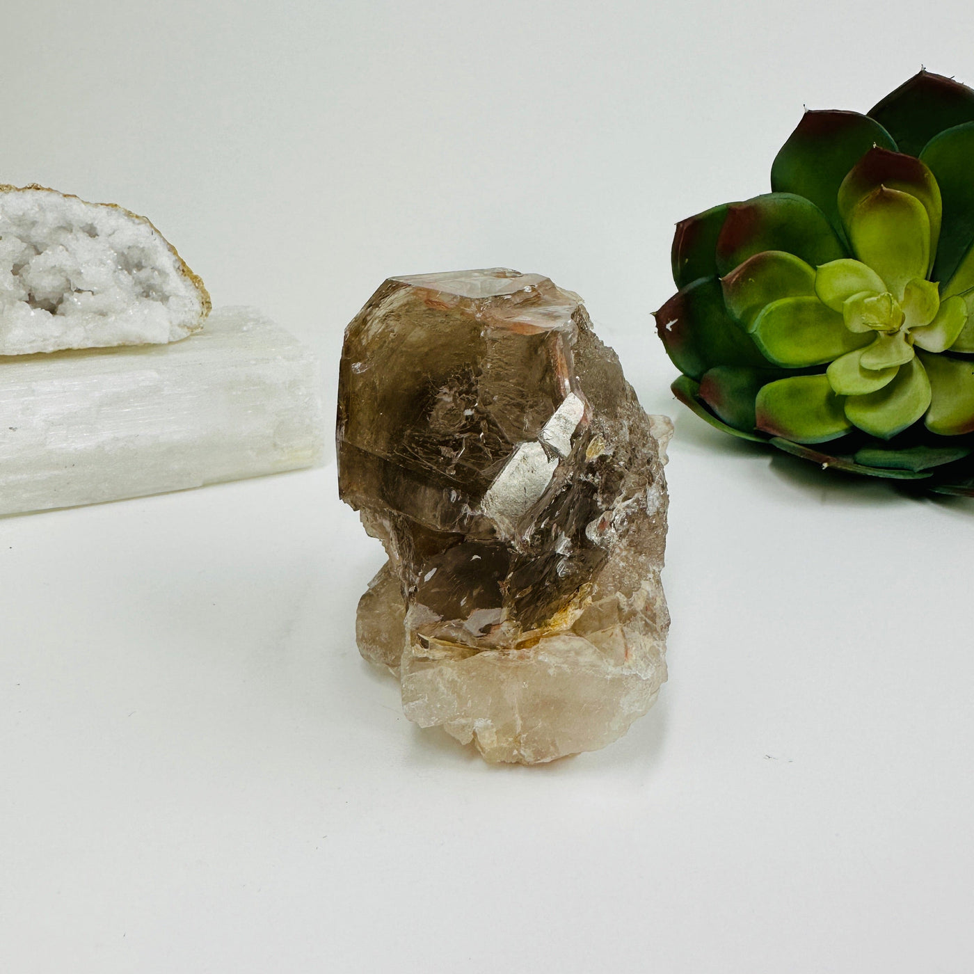 side view of Smokey quartz cluster with decorations in the background